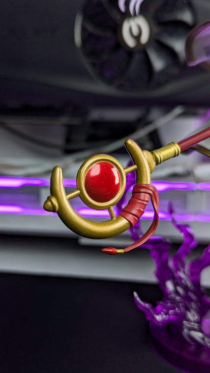 Detail of Frieren's staff head with its red orb and wrapped grip