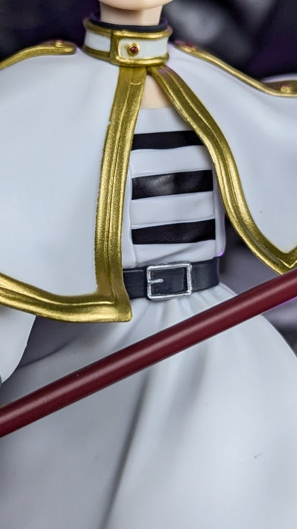 Detail of the white cape, gold trim, striped collar and belt